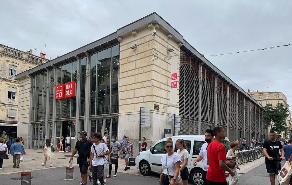 La façade de verre et de métal des halles Castellane, rue de la Loge à Montpellier, avec des passants