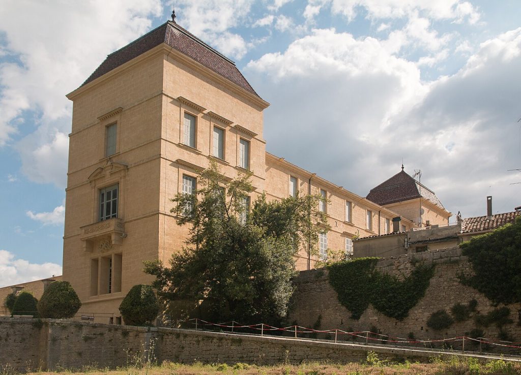 La façade ouest du château de Castries, en pierre claire, au-dessus d’un mur de soutènement