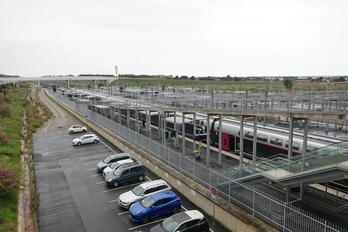 La gare de Montpellier Sud de France, un TER à quai et les parkings, au milieu des terrains encore nus de Cambacérès